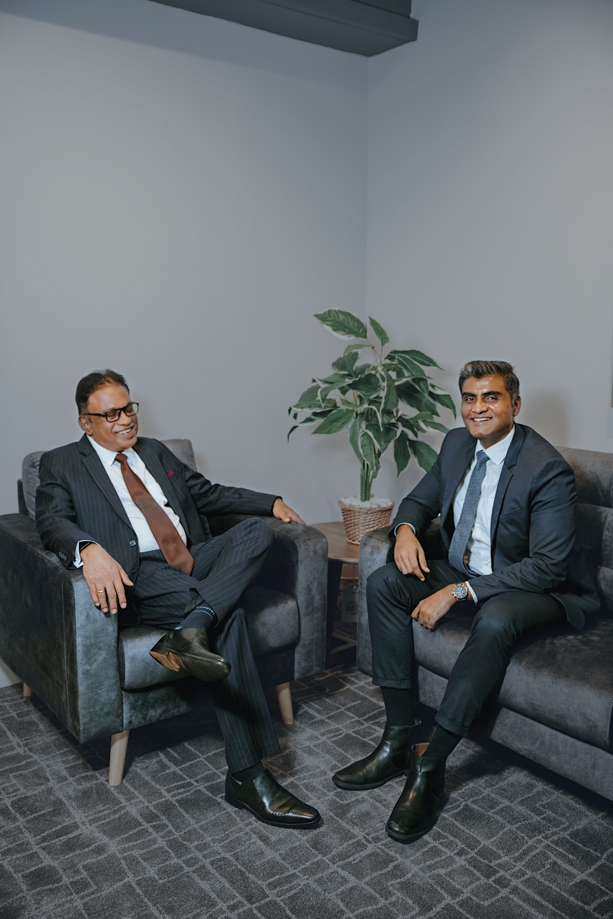 Dato' George Varughese and Vinobha Anthony Doss seated in conversation in the office lounge